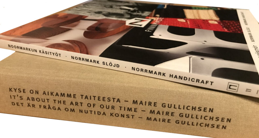 Two volumes in Pori Art Museum Publications series on top of one another. The volumes are Noormarkun Käsityöt and Kyse on aikamme taiteesta – Maire Gullichsen.