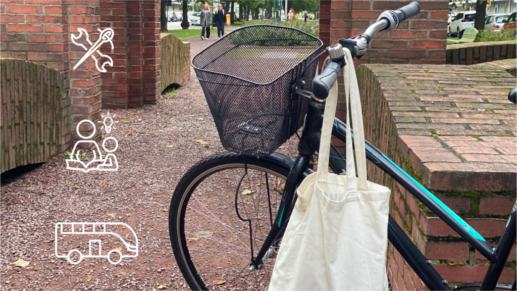 Parkkeerattu polkupyörä puistossa. Polkupyörän tangosta riippuu kangaskassi.