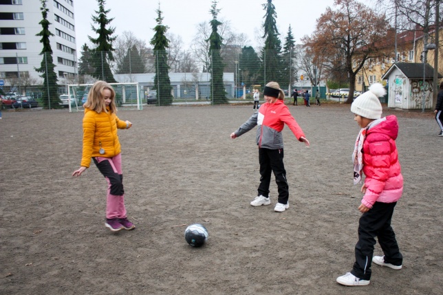 Lapset leikkivät jalkapallolla 