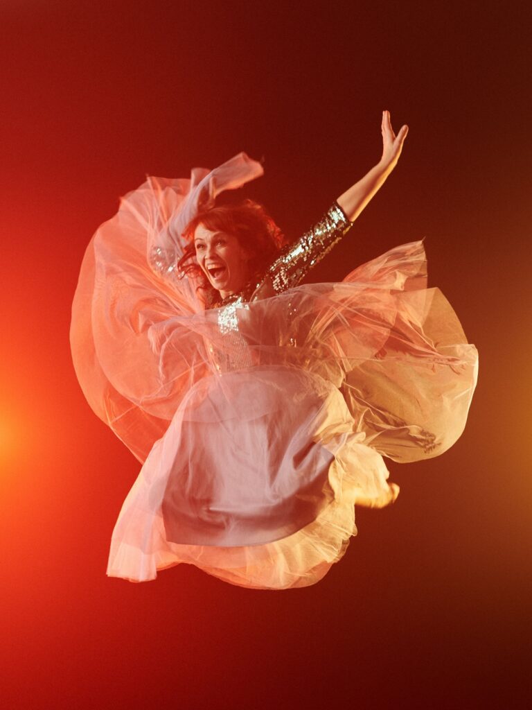 Tanssija Kati Aalto vaalenpunertavassa mekossa hypänneenä ilmaan.