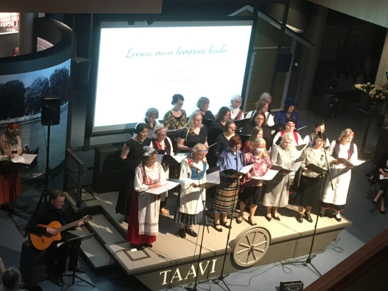 Ryhmä naisia laulaa yhdessä Satakunnan Museon Taavi-lavalla