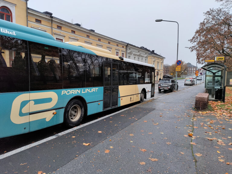 Porin Linjojen bussi syysmaisemassa Keski-Porin kirkon bussipysäkillä