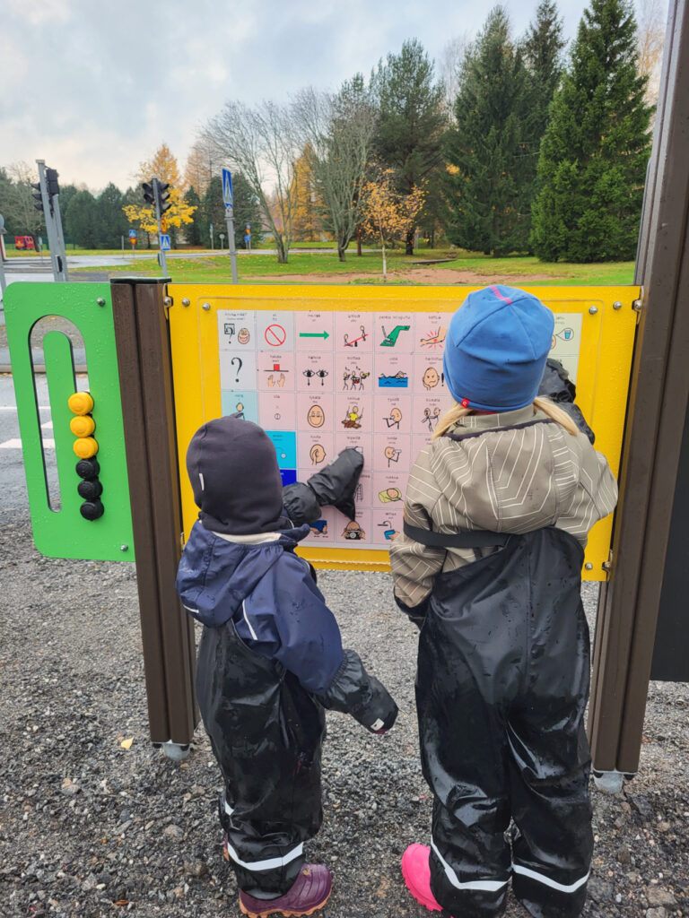 Kaksi lasta käyttää liikennepuisto Vinkkarin kommunikaatiopistettä