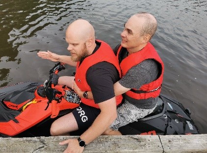 Kaksi ihmistä pelastusliivien kanssa vesijetin päällä.