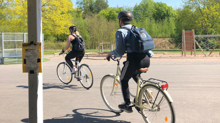 Kuvassa on kaksi henkilöä pyöräilemässä.