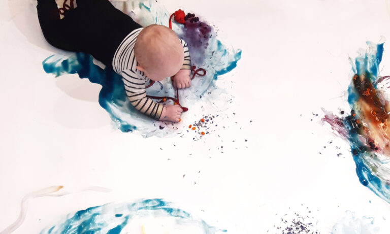 Vauva maalaa vatsallaan marjoilla ja muilla Värikylpy-maaleilla.