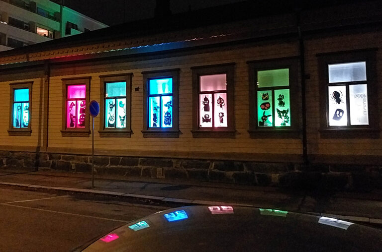Eri värein valaistuja ikkunoita talossa