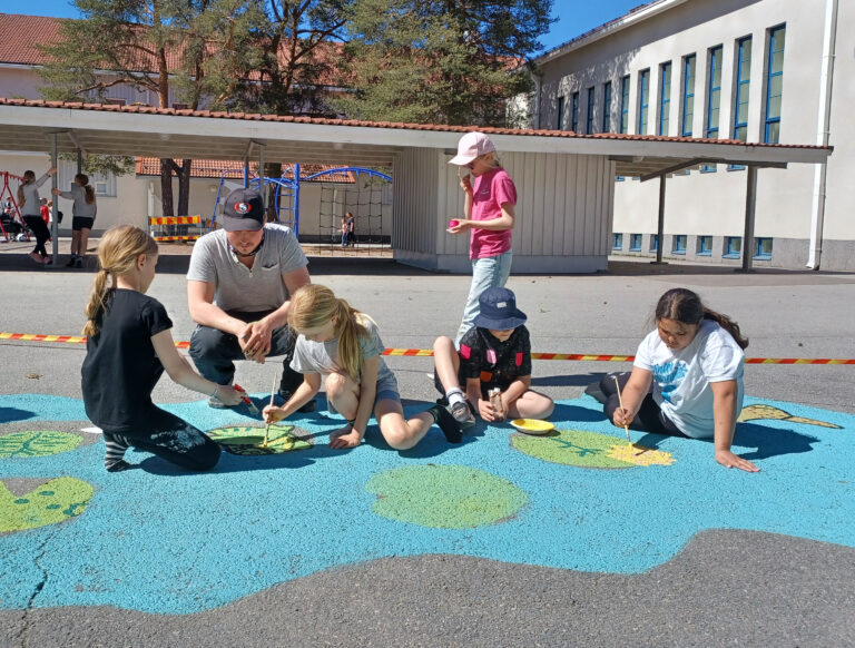 Lapsia maalaamassa Käppärän koulun pihalle teosta leikkimistä varten