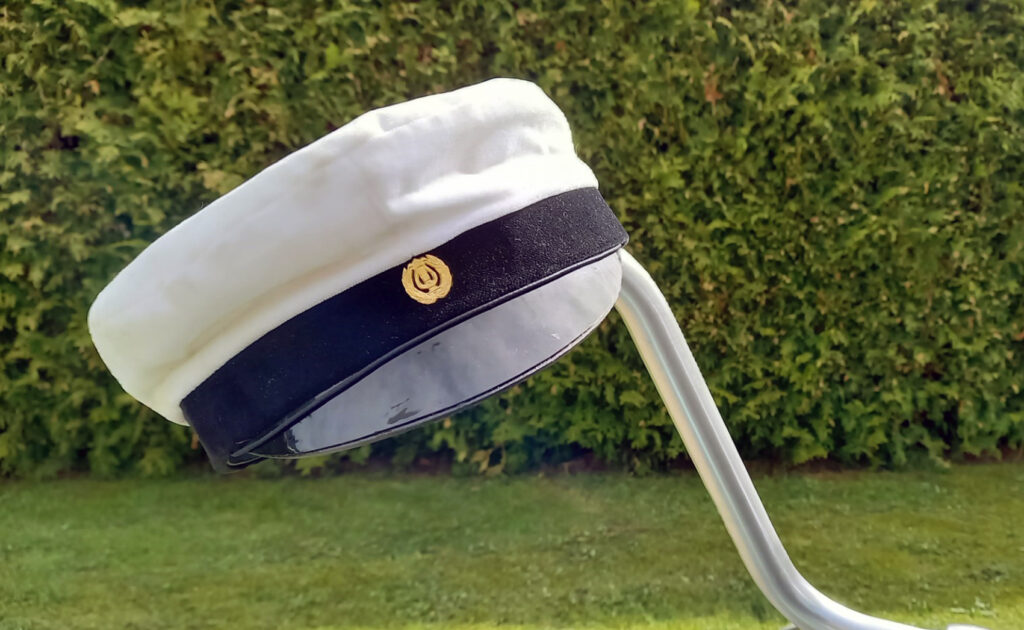Ylioppilaslakki pyörän sarvessa, taustalla vihreää pensaskasvillisuutta.