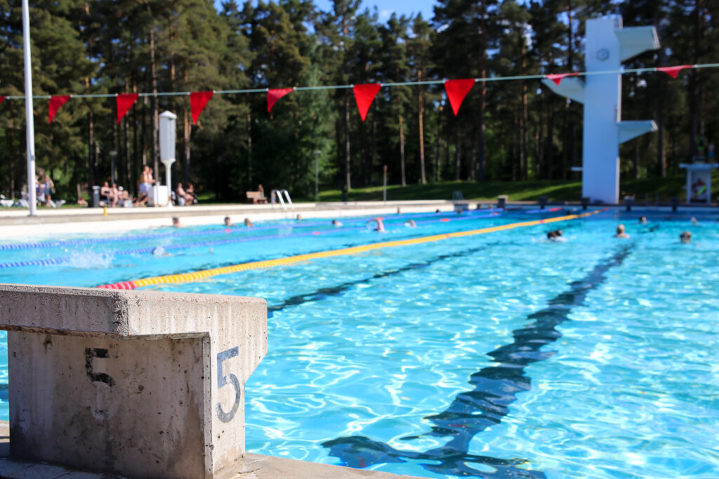 Lähikuvassa kirkasvesinen uima-allas ja taustalla puita