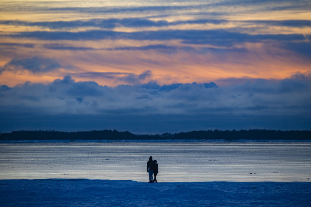 A couple on a winter beach at sunset