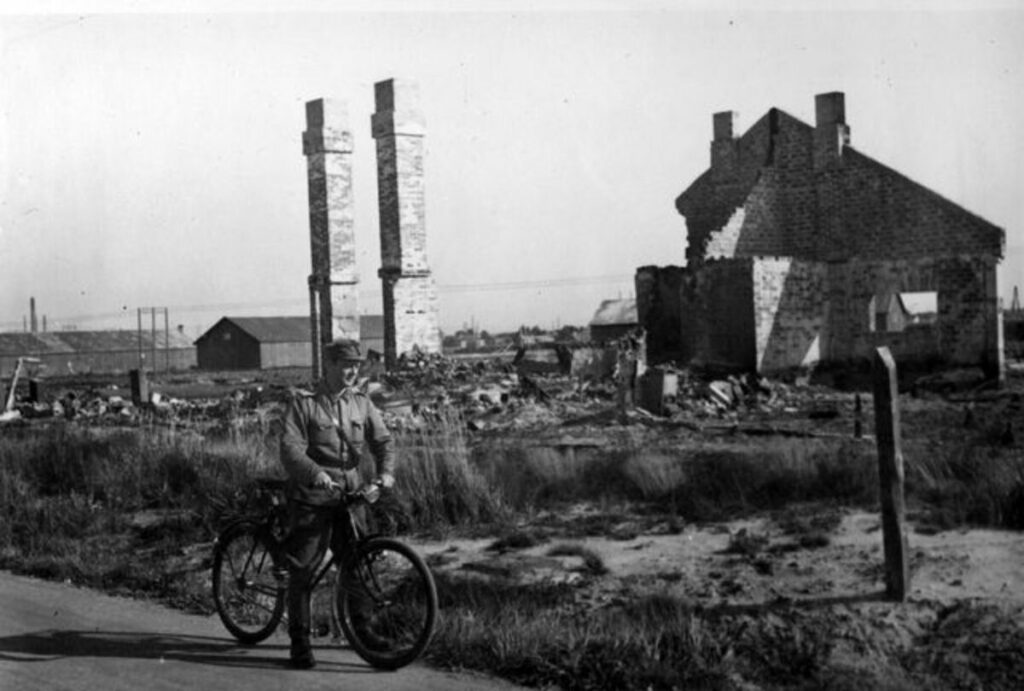 Mustavalkokuvassa pyöräilevä sotilas, taustalla rakennuksia